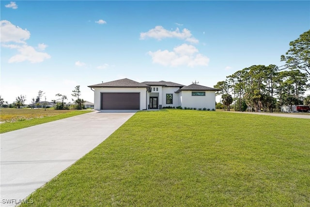 prairie-style home with an attached garage, driveway, a front lawn, and stucco siding