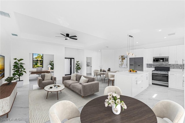 living room with a ceiling fan, recessed lighting, marble finish floor, and visible vents