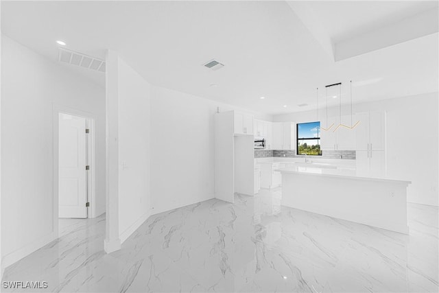 unfurnished living room featuring baseboards, marble finish floor, visible vents, and recessed lighting