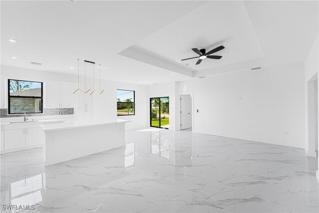 interior space featuring a sink, visible vents, a ceiling fan, marble finish floor, and a raised ceiling