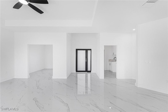 empty room featuring marble finish floor, ceiling fan, visible vents, and a sink