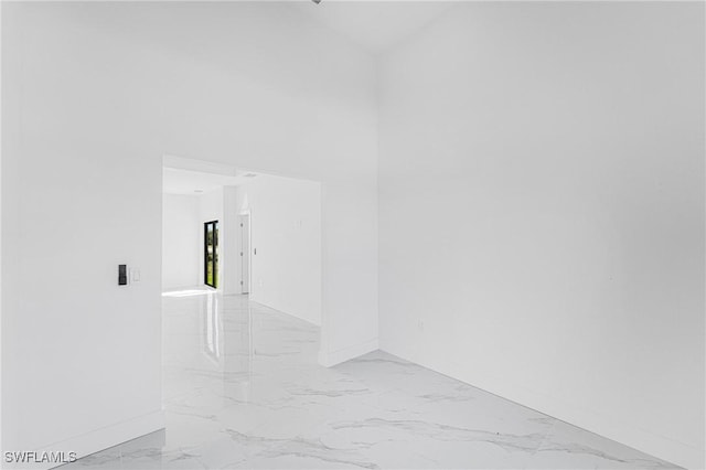 interior space with marble finish floor and a towering ceiling