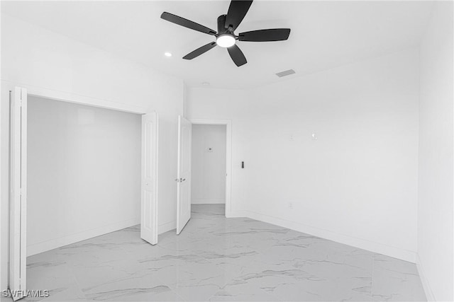 interior space featuring marble finish floor, a ceiling fan, visible vents, and baseboards