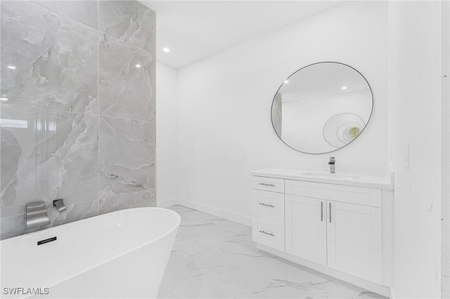 full bath with recessed lighting, vanity, baseboards, marble finish floor, and a soaking tub