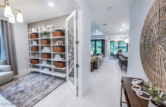 corridor featuring recessed lighting, visible vents, and an inviting chandelier