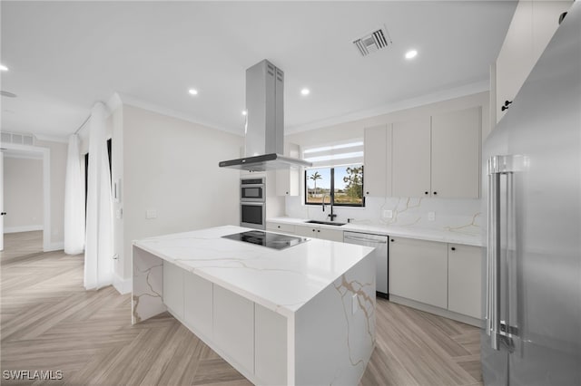 kitchen with island range hood, a kitchen island, a sink, visible vents, and appliances with stainless steel finishes