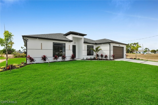 prairie-style home featuring roof with shingles, stucco siding, concrete driveway, a garage, and a front lawn