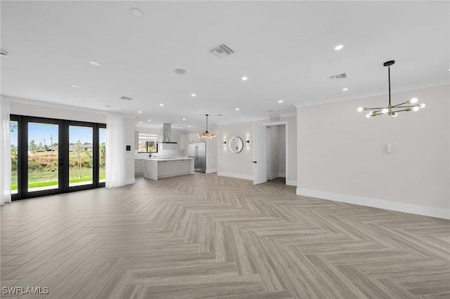 unfurnished living room featuring baseboards, visible vents, a notable chandelier, and ornamental molding