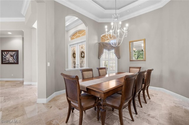 dining space featuring arched walkways, a high ceiling, baseboards, french doors, and ornamental molding