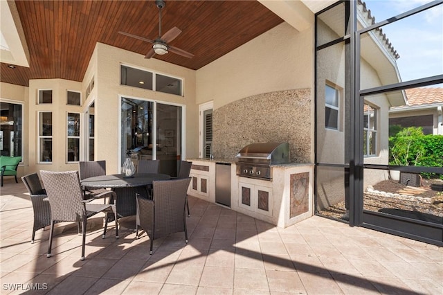 view of patio / terrace featuring glass enclosure, outdoor dining area, area for grilling, a ceiling fan, and grilling area