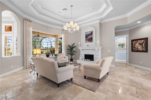 living area featuring a fireplace, stone tile flooring, a raised ceiling, visible vents, and baseboards