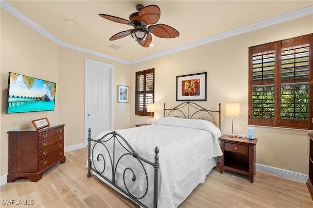 bedroom featuring light wood-type flooring, visible vents, crown molding, and baseboards