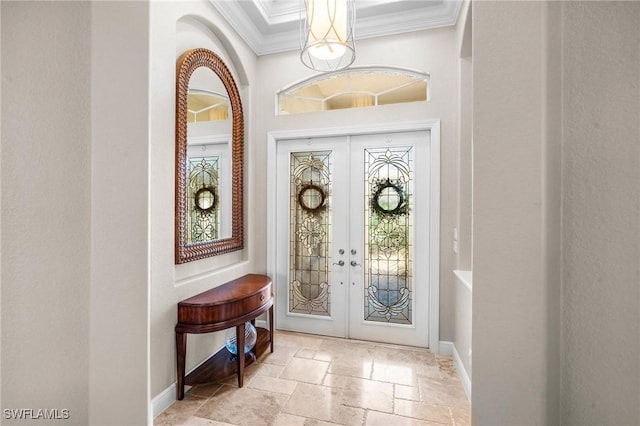 entrance foyer with baseboards, ornamental molding, stone tile flooring, and french doors