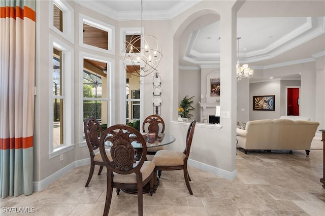 dining space featuring ornamental molding, a fireplace, baseboards, and an inviting chandelier