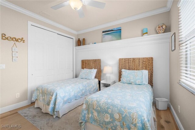 bedroom featuring ceiling fan, a closet, ornamental molding, and wood finished floors