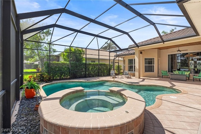 view of swimming pool featuring glass enclosure, a pool with connected hot tub, a patio area, and ceiling fan