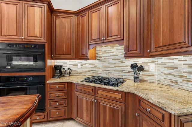 kitchen featuring light stone countertops, black appliances, brown cabinetry, and decorative backsplash