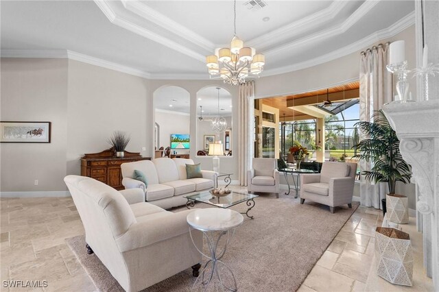 living room featuring a chandelier, a tray ceiling, baseboards, and stone tile floors