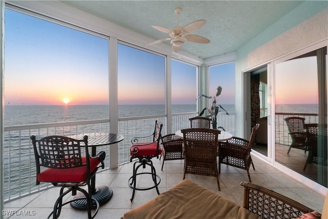 sunroom with a water view and ceiling fan