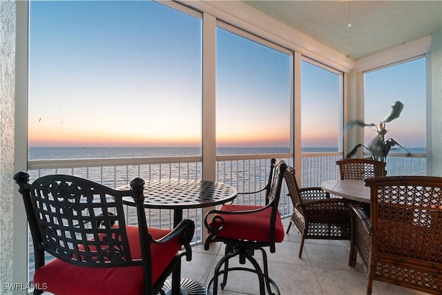 sunroom featuring a water view