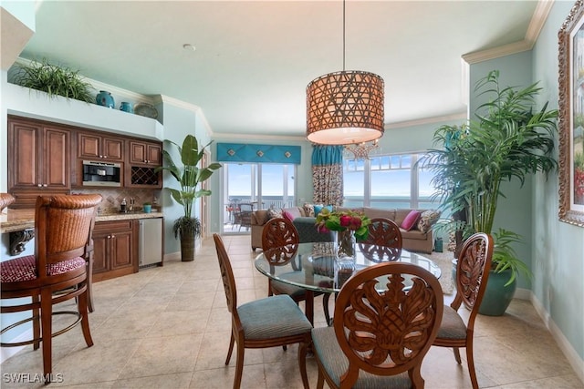 dining area featuring ornamental molding, baseboards, and light tile patterned floors