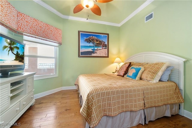 bedroom featuring visible vents, crown molding, baseboards, and hardwood / wood-style flooring