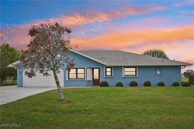 ranch-style house with stucco siding, a shingled roof, concrete driveway, a garage, and a front lawn