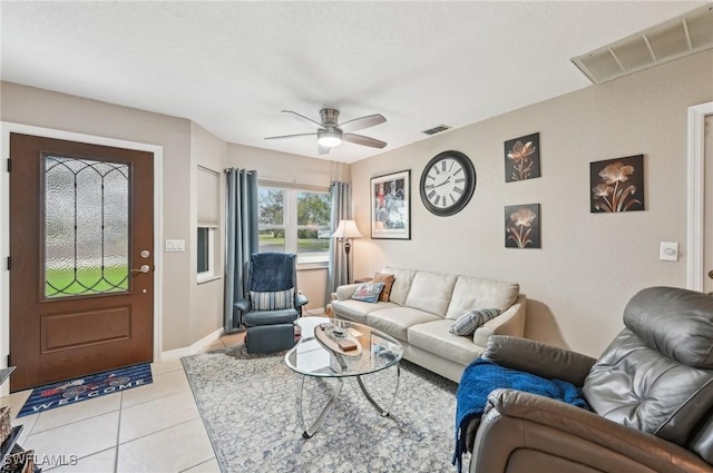 living room with visible vents, ceiling fan, baseboards, and light tile patterned floors