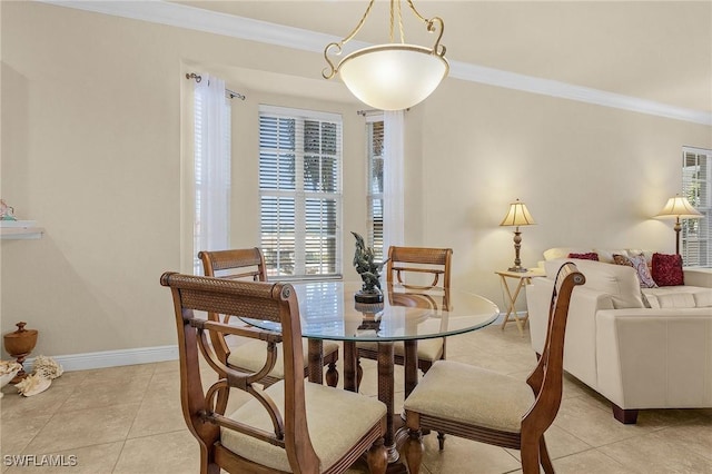 dining area with light tile patterned flooring, baseboards, and ornamental molding
