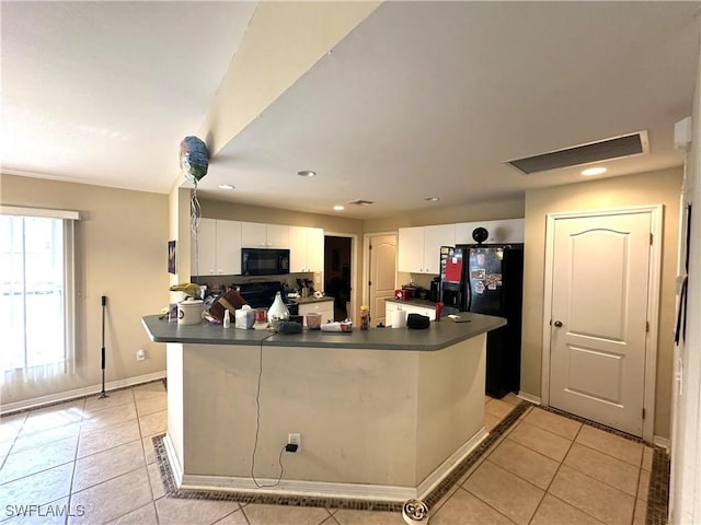 kitchen with dark countertops, white cabinetry, black appliances, and light tile patterned flooring