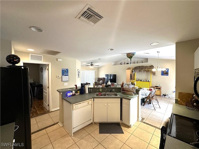 kitchen featuring dark countertops, visible vents, freestanding refrigerator, white dishwasher, and a sink