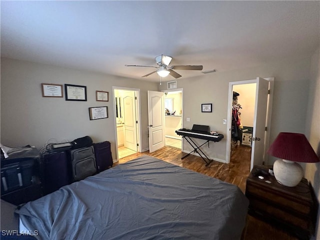 bedroom with a ceiling fan, visible vents, wood finished floors, and ensuite bathroom