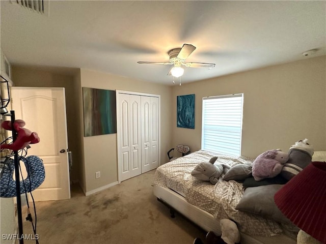 bedroom with ceiling fan, light carpet, visible vents, baseboards, and a closet