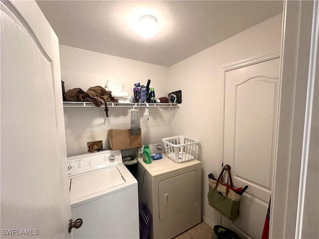 laundry area with washer and dryer, laundry area, and light tile patterned flooring