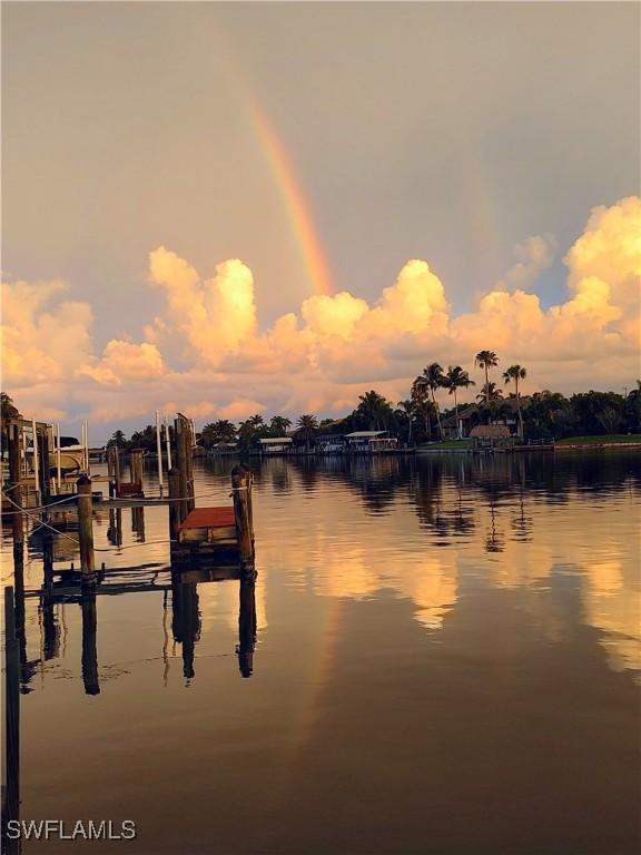 property view of water featuring boat lift and a dock