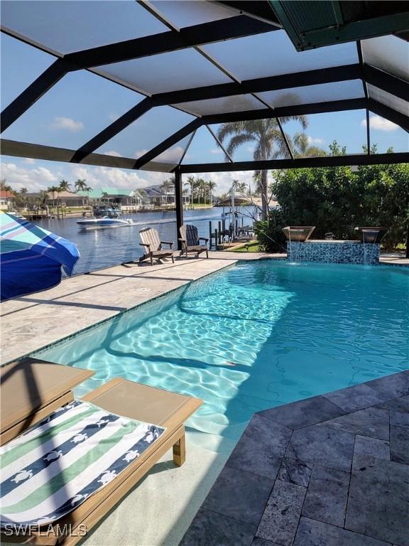 outdoor pool featuring a water view, a lanai, and a patio area