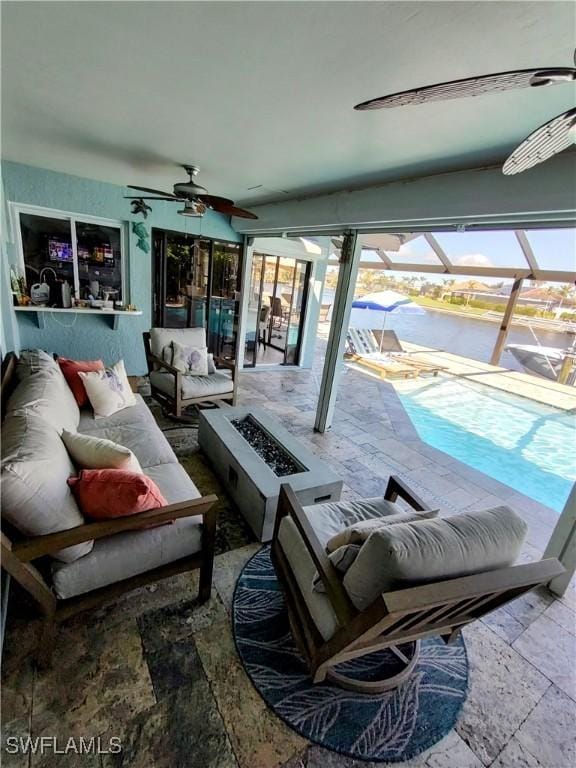 interior space with an outdoor living space with a fire pit, a lanai, and ceiling fan