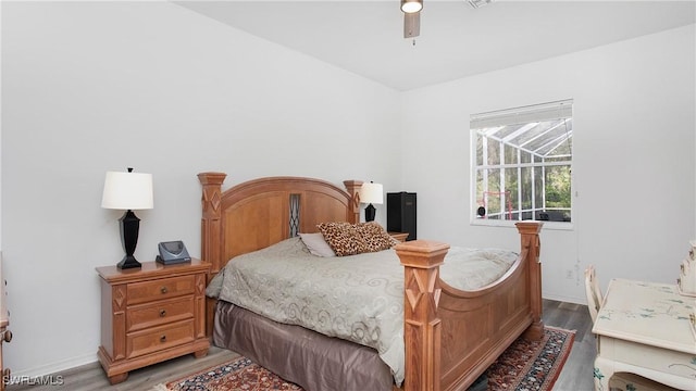 bedroom featuring a ceiling fan, a sunroom, light wood-style flooring, and baseboards