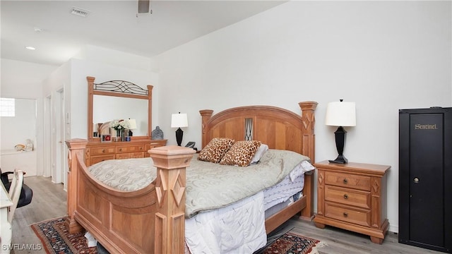 bedroom with light wood-style floors and visible vents