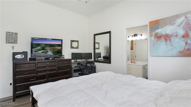 bedroom with dark wood-style floors, ensuite bath, and baseboards