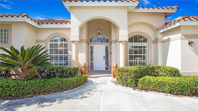 property entrance featuring a tile roof and stucco siding