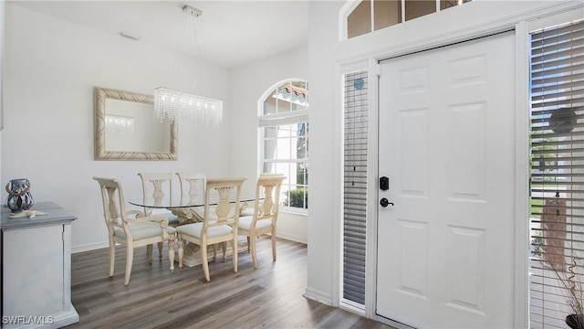 interior space featuring baseboards, a chandelier, and wood finished floors