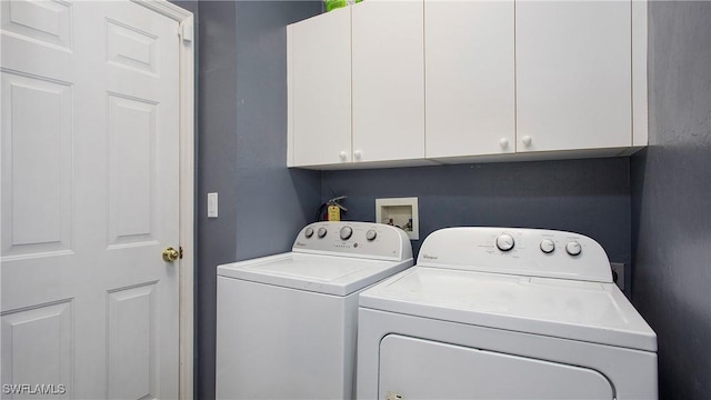 clothes washing area featuring cabinet space and separate washer and dryer