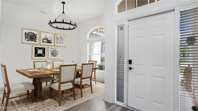 dining area with wood finished floors and an inviting chandelier