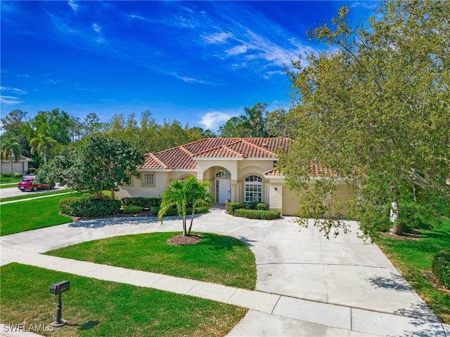 mediterranean / spanish house with driveway, a front lawn, a tile roof, and stucco siding