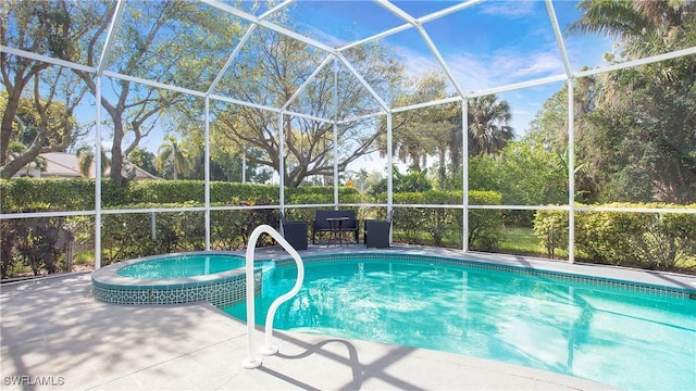 view of pool featuring glass enclosure, a pool with connected hot tub, and a patio