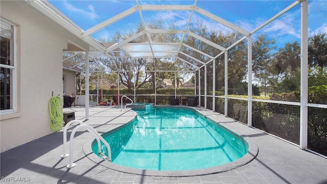 view of swimming pool featuring a pool with connected hot tub, a lanai, and a patio