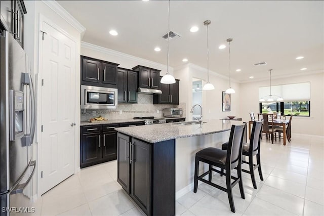 kitchen with a kitchen bar, ornamental molding, a sink, backsplash, and stainless steel appliances