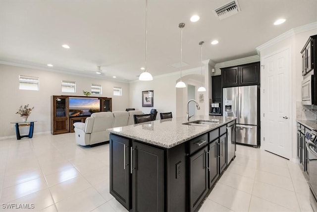 kitchen featuring visible vents, a sink, dark cabinetry, appliances with stainless steel finishes, and crown molding