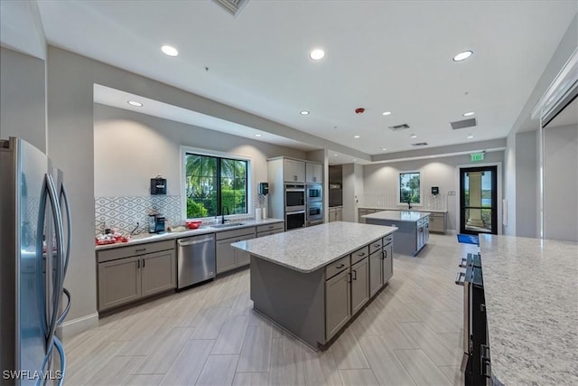 kitchen featuring visible vents, gray cabinets, appliances with stainless steel finishes, and a center island